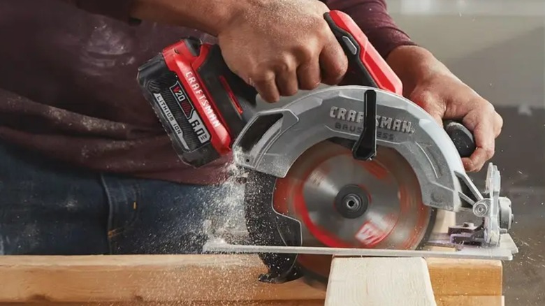 Man using circular saw on wood