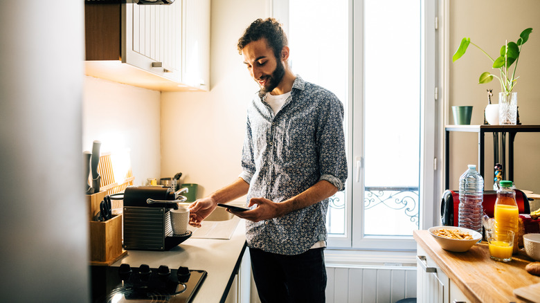 man in kitchen making coffee with coffee maker