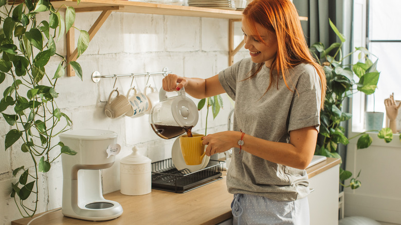 woman pouring coffee into a coffee mug