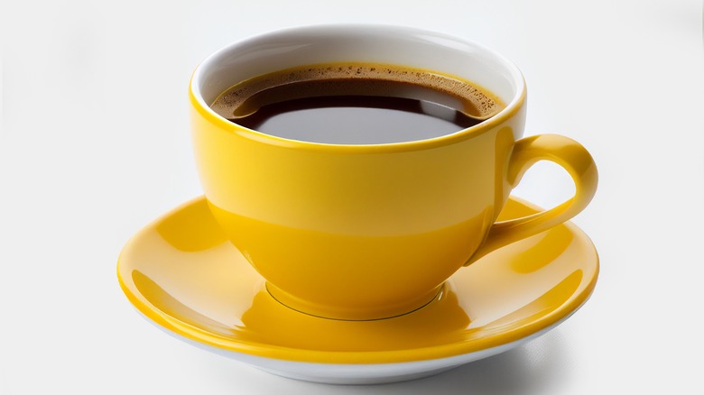 yellow cup of coffee on saucer