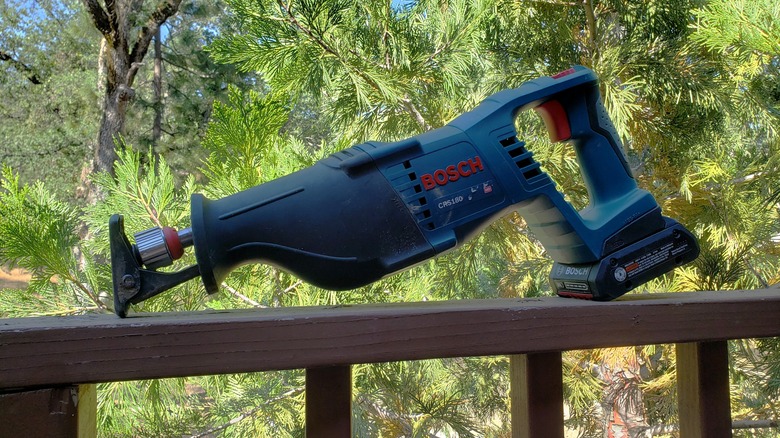 Well-used Bosch cordless reciprocating saw on a railing