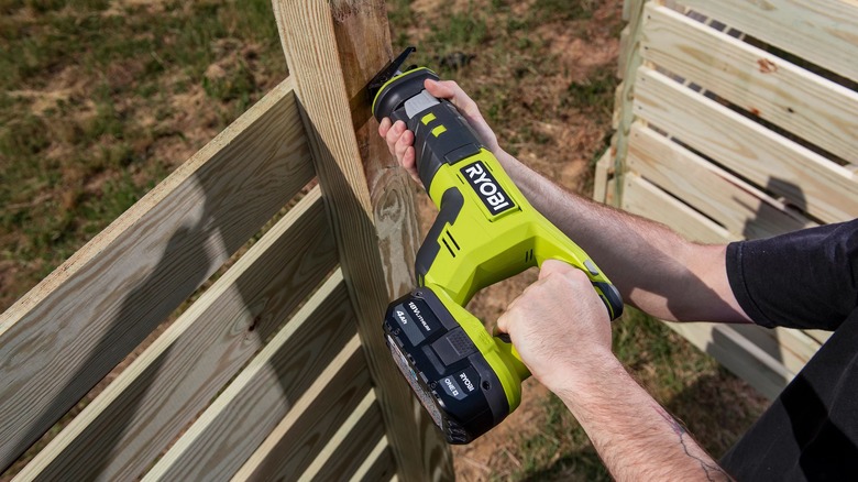 Person using a Ryobi reciprocating saw