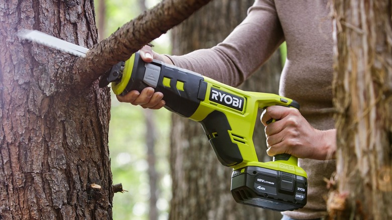 Person using a Ryobi cordless reciprocating saw