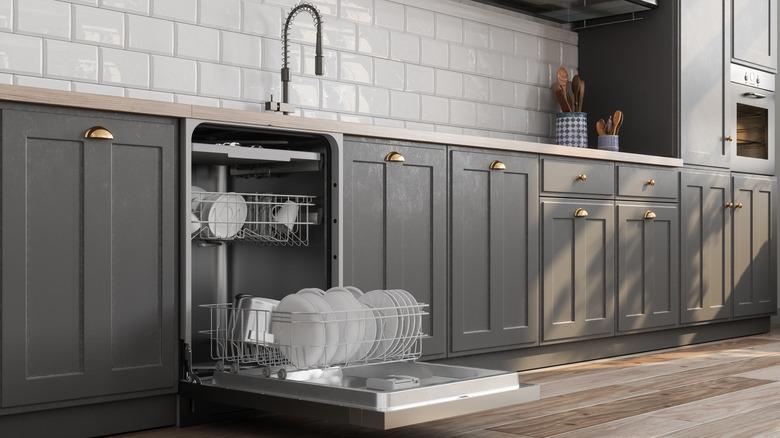 Close-up View Of Open Dishwasher With Kitchen Utensils In It