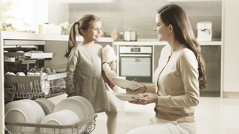 Mother and daughter next to an LG dishwasher in kitchen