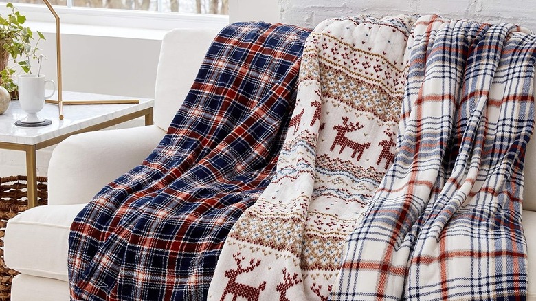 Trio of Smart Heated Electric Throw Blankets lined up on a couch.