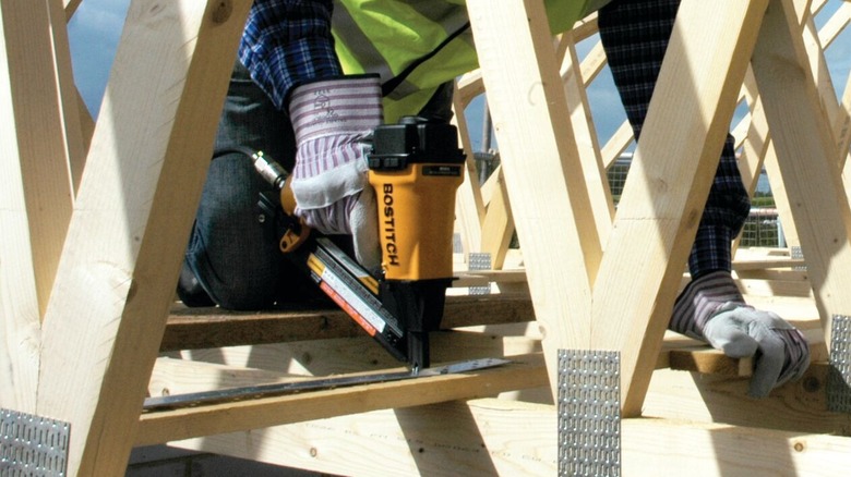 person using Bostitch framing nailer on wood