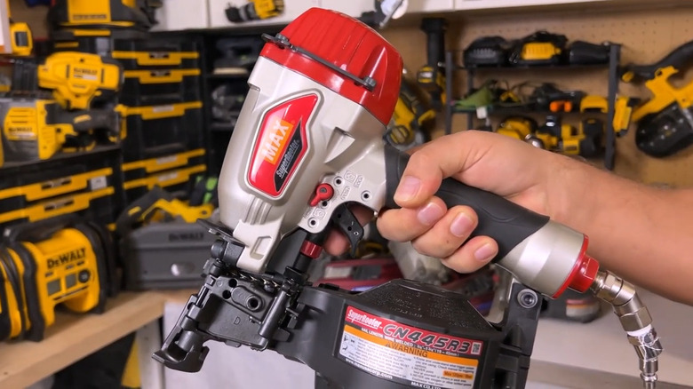 Person holding Max framing nailer in front of other tools