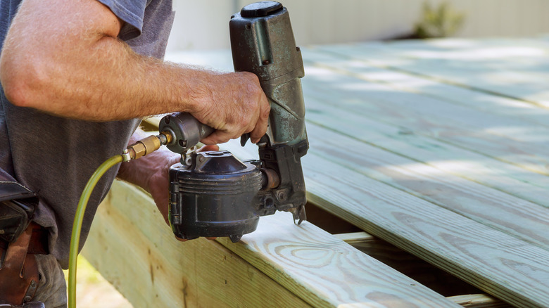 Person using nailer on deck