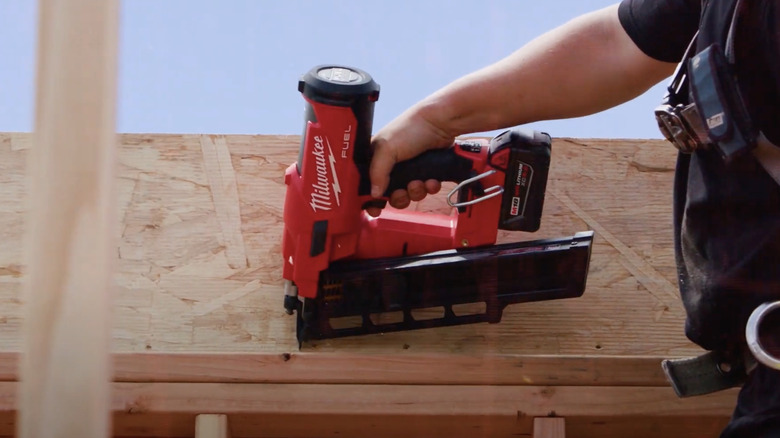 Milwaukee framing nailer on lumber stack