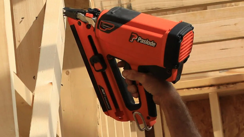 Person using Paslode nailer on framing