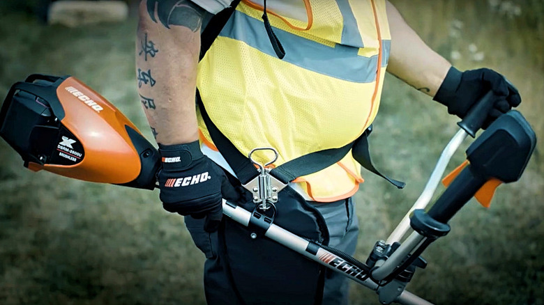 A landscaper operating a pro-grade Echo string trimmer.