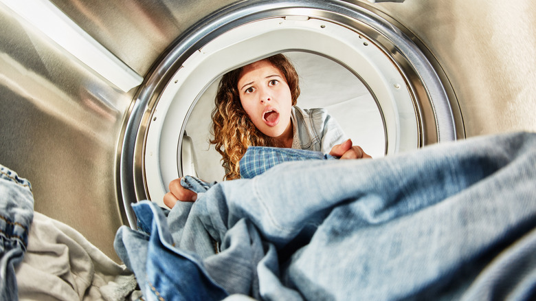 woman with mouth open looking into dryer