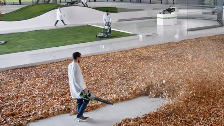 Person in lab coat using Ego leaf blower