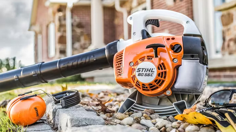 Stihl leaf blower on ground with gloves and ear protection