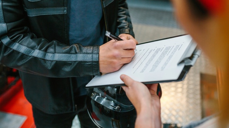 a biker signing an insurance contract