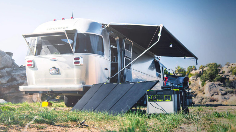 Goal Zero portable power station and solar panel outside an Airstream trailer