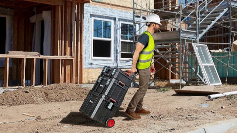 Man rolling Bauer toolboxes on construction site