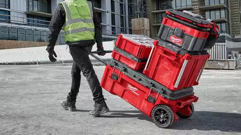 Person pulling Milwaukee toolboxes across job site