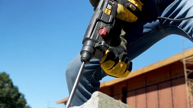 a wall with yellow power drills hanging on it