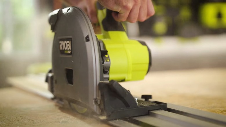 man using a chainsaw to cut a log