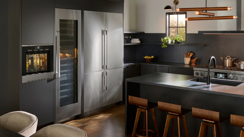 A kitchen with gray counters and silver appliances