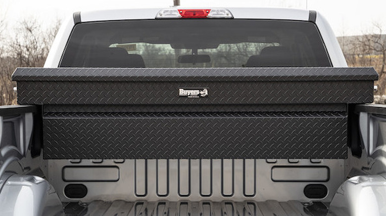 Bed of pickup with black toolbox mounted near cab