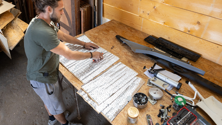 Man cutting with a knife on a workbench