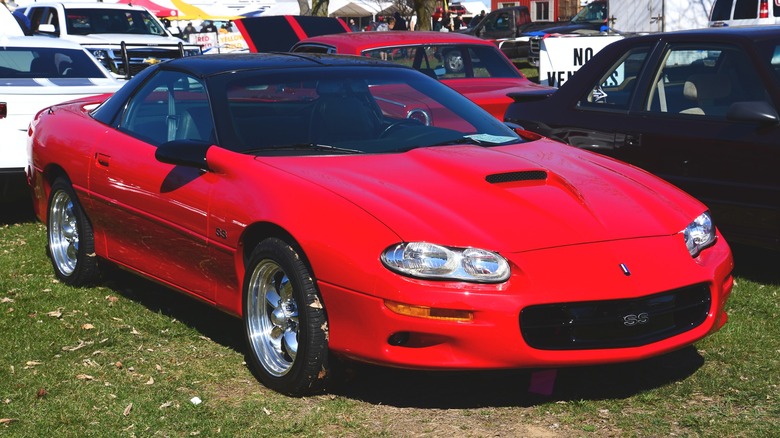 Red 1998 Chevrolet Camaro SS parked on grass