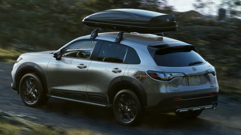 A 2025 Honda HR-V with roof rack driving on a gravel road.