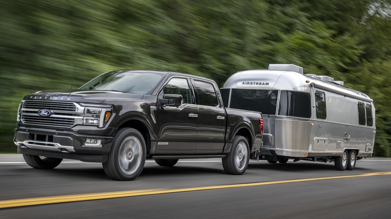 black Ford F-150 pulling trailer