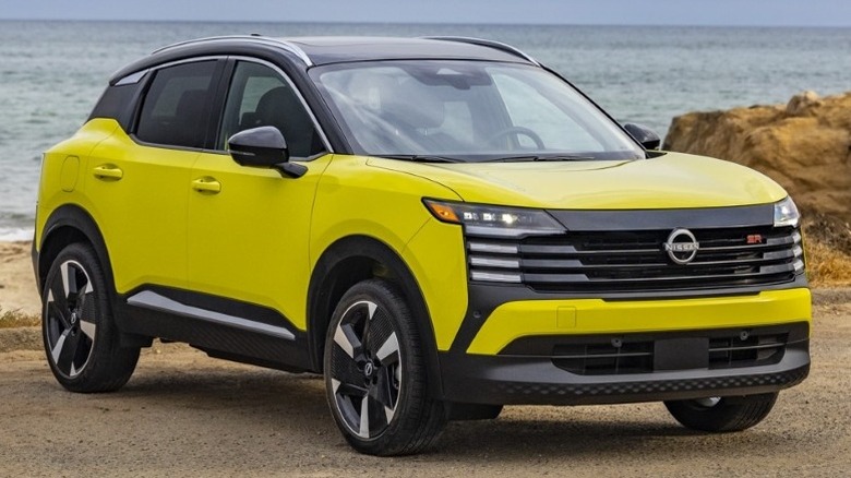 2025 Nissan Kicks parked on a paved surface with a water body in the background