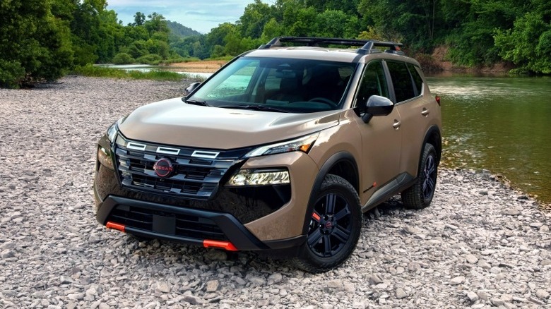 2025 Nissan Rogue Rock Creek edition parked on a riverbank with trees