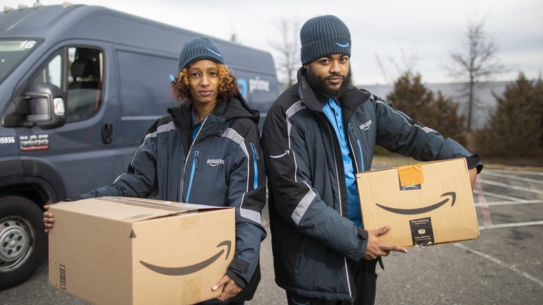 Two Amazon workers holding boxes