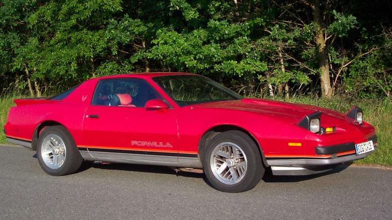 Third-gen Pontiac Firebird with headlights on