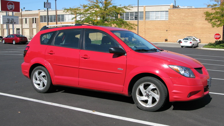 A red Pontiac Vibe at a parking lot, front 3/4 view