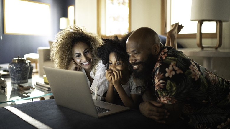 a family watching a movie on a laptop