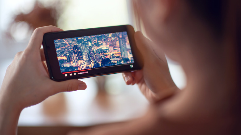 woman streaming a movie on a smartphone