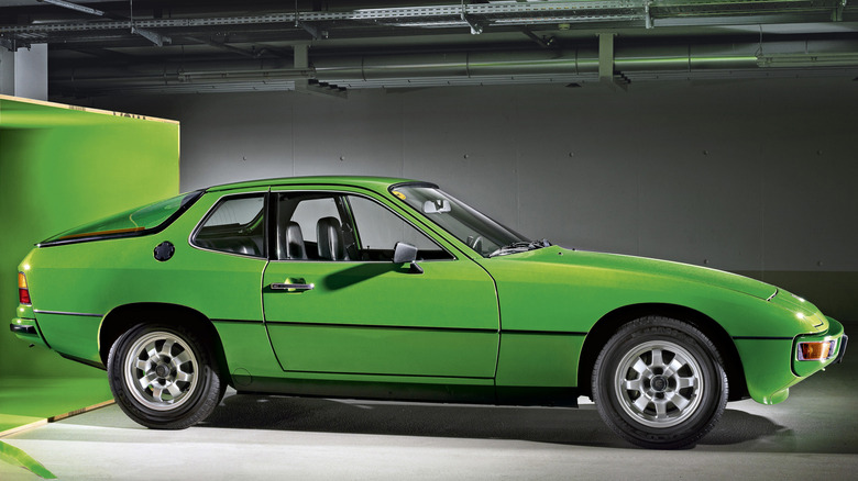 A lime green Porsche 924 indoors, having emerged from a large crate.