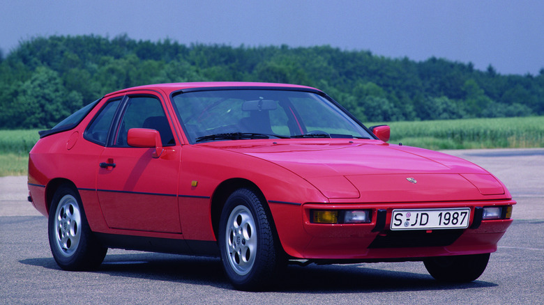 A red 1987 Porsche 924S against a background of grass and trees.