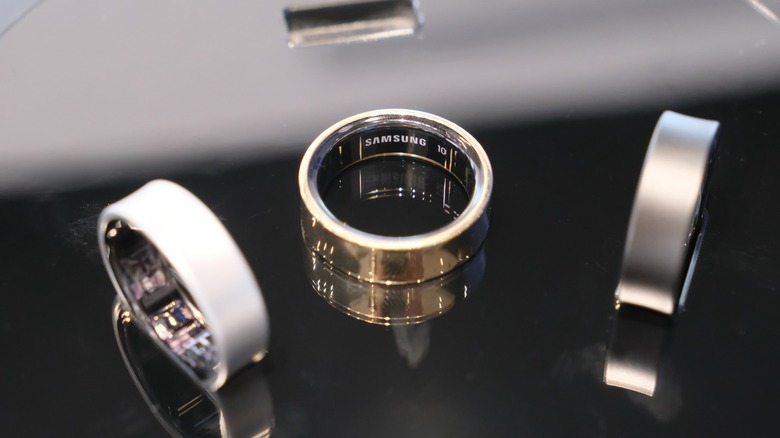 Samsung's line of Galaxy Rings in gold, titanium, and black on reflective surface