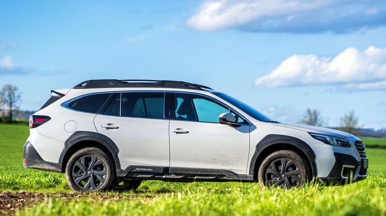 White Subaru Outback with landscape