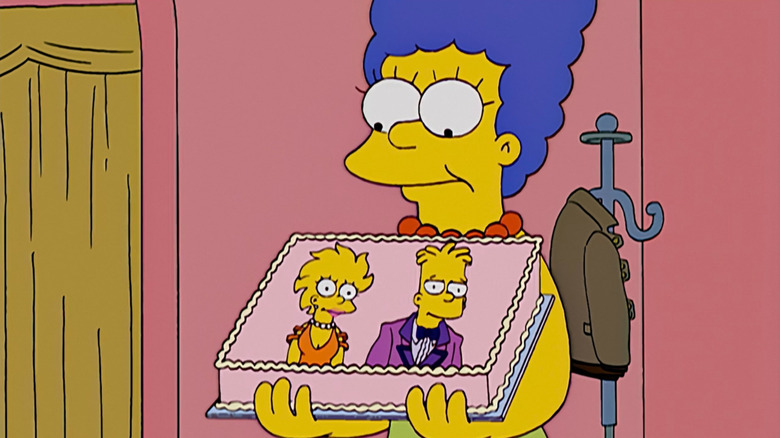 Marge holding a cake with a picture of Bart and Lisa