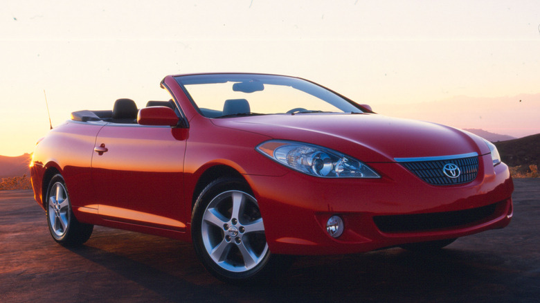 A red 2004 Toyota Camry Solara Convertible with the sun glinting off its rear.