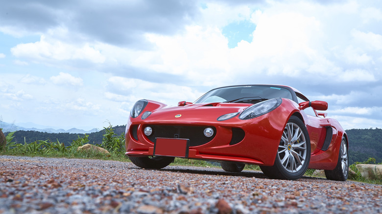 A red Lotus Elise on a gravel road