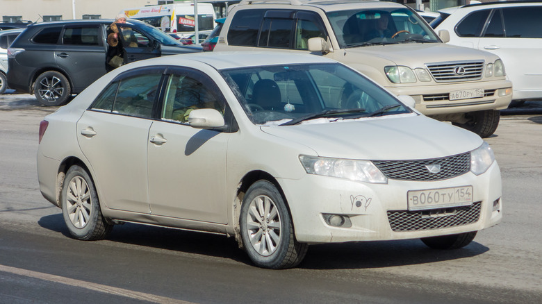 A white Toyota Allion in a parking lot