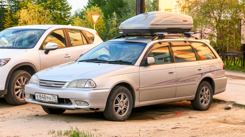 A gray Toyota Caldina parked at a beach