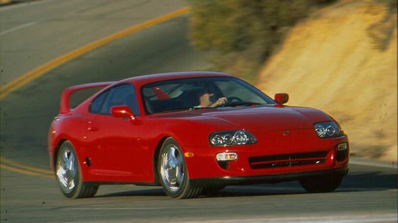 Red Toyota Supra A80 cornering at high speed