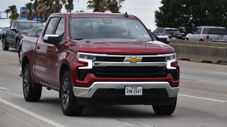 burgandy Chevrolet Silverado pickup truck driving highway