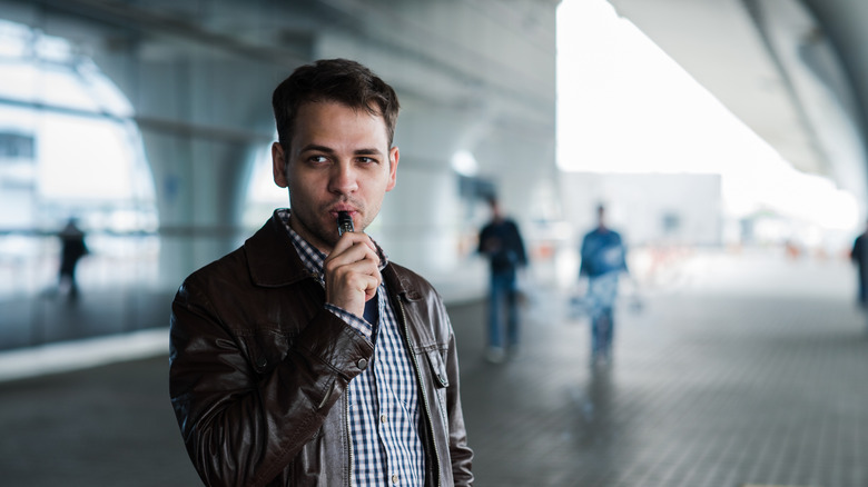 A man vaping before going inside the airport